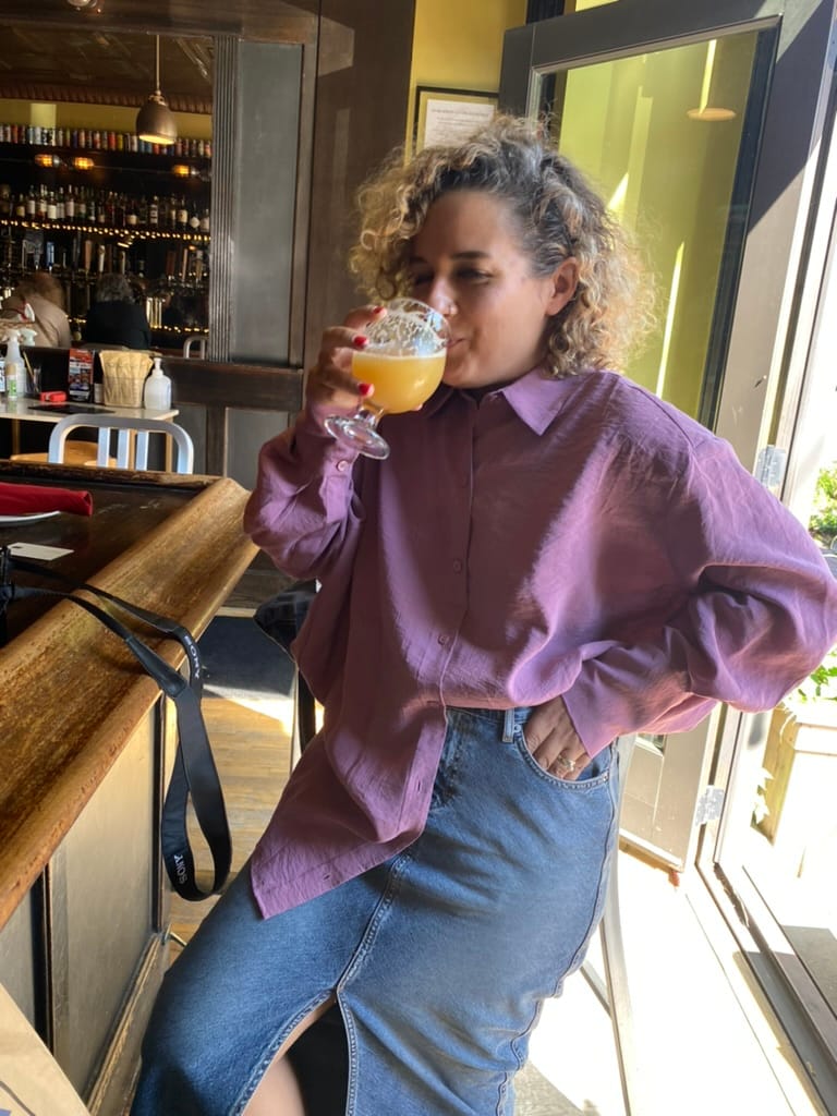 Alicia Kennedy takes a sip of a beer in a bar.